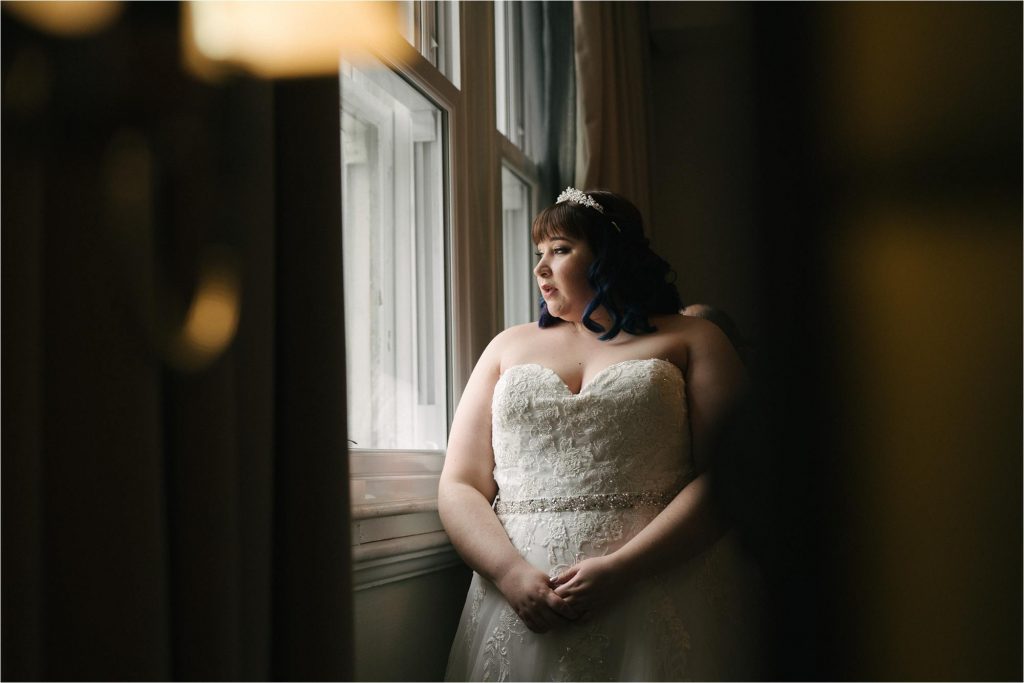 bride looking out of window about to get married 