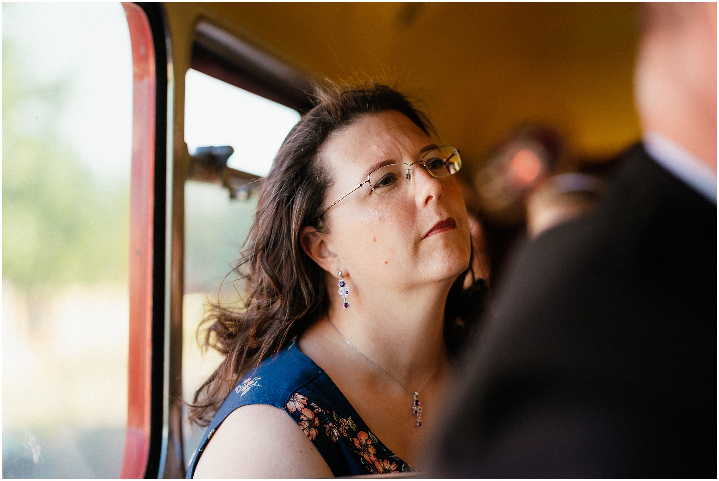 Wedding guests riding a vintage red wedding bus. 