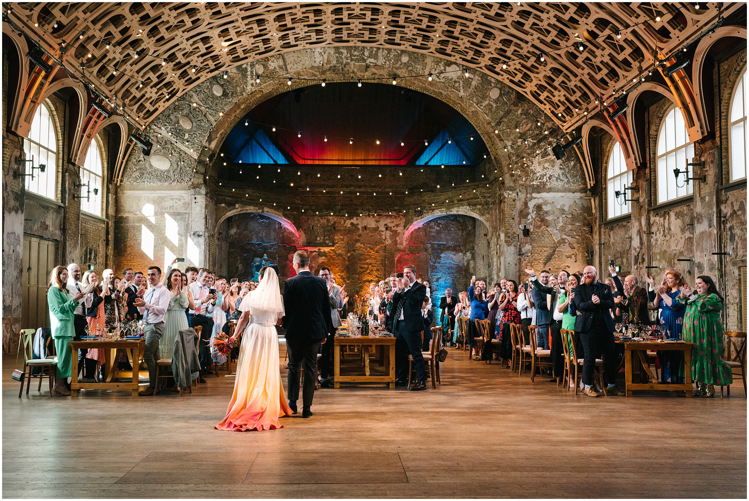 A bride and groom enter the room at the Battersea Arts Centre. 