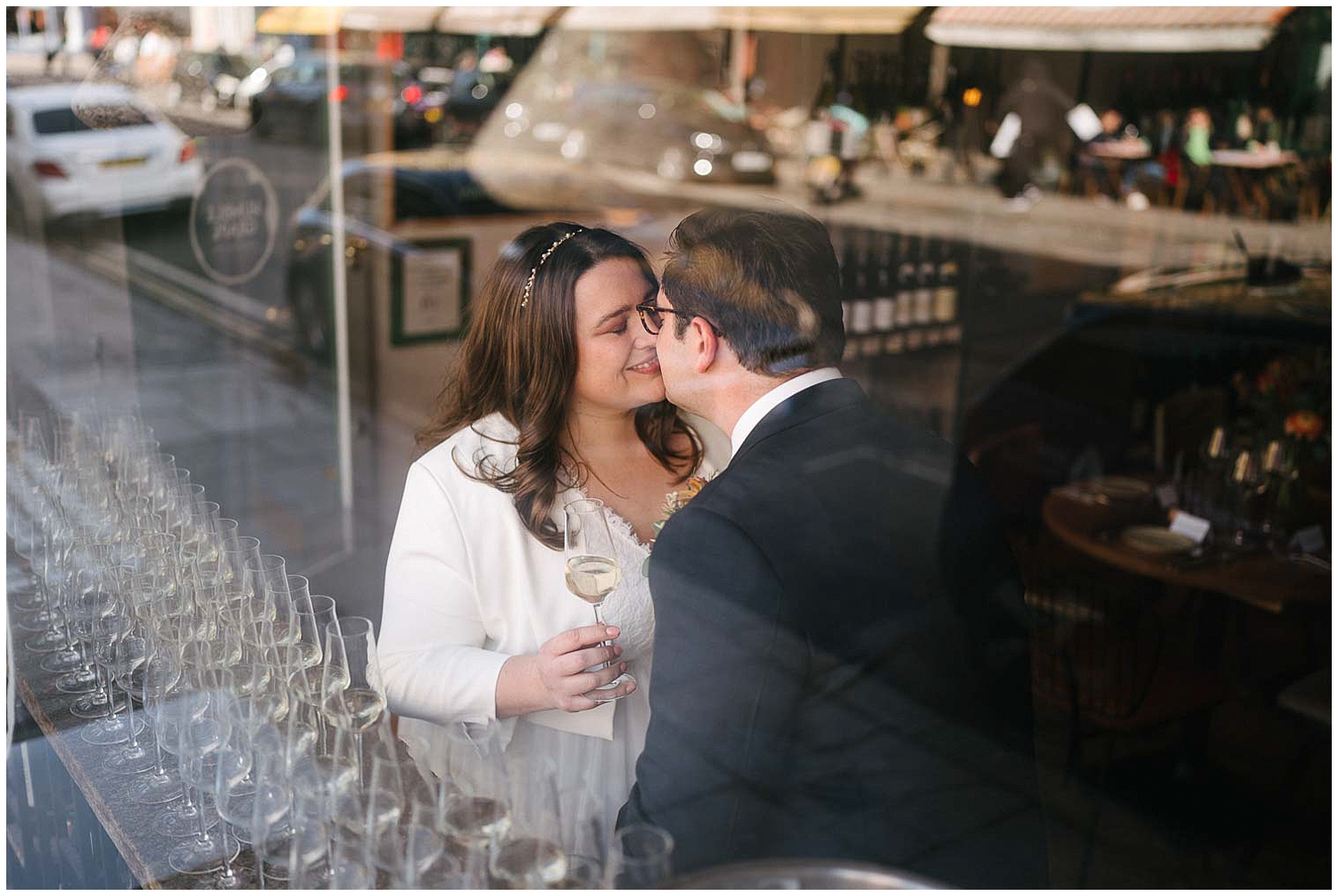A couple kissing through a window on their wedding day. Photographed by Yorkshire Wedding Photographer Kari Bellamy. 