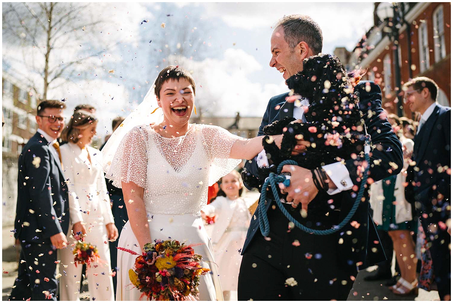 A confetti shot of a couple with their dog outside Battersea Arts Centre. Photographed by award winning Yorkshire wedding photographer Kari Bellamy. 