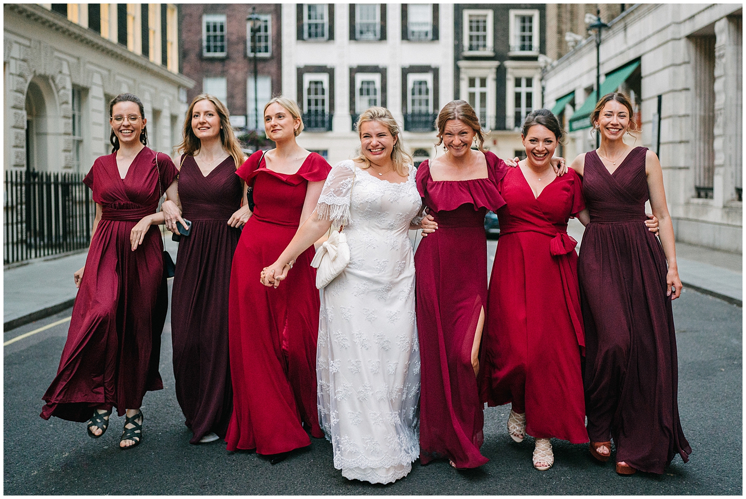 A bride and bridesmaids walking down a street outside of the RSA in Central London. Photographed by Kari Bellamy. 