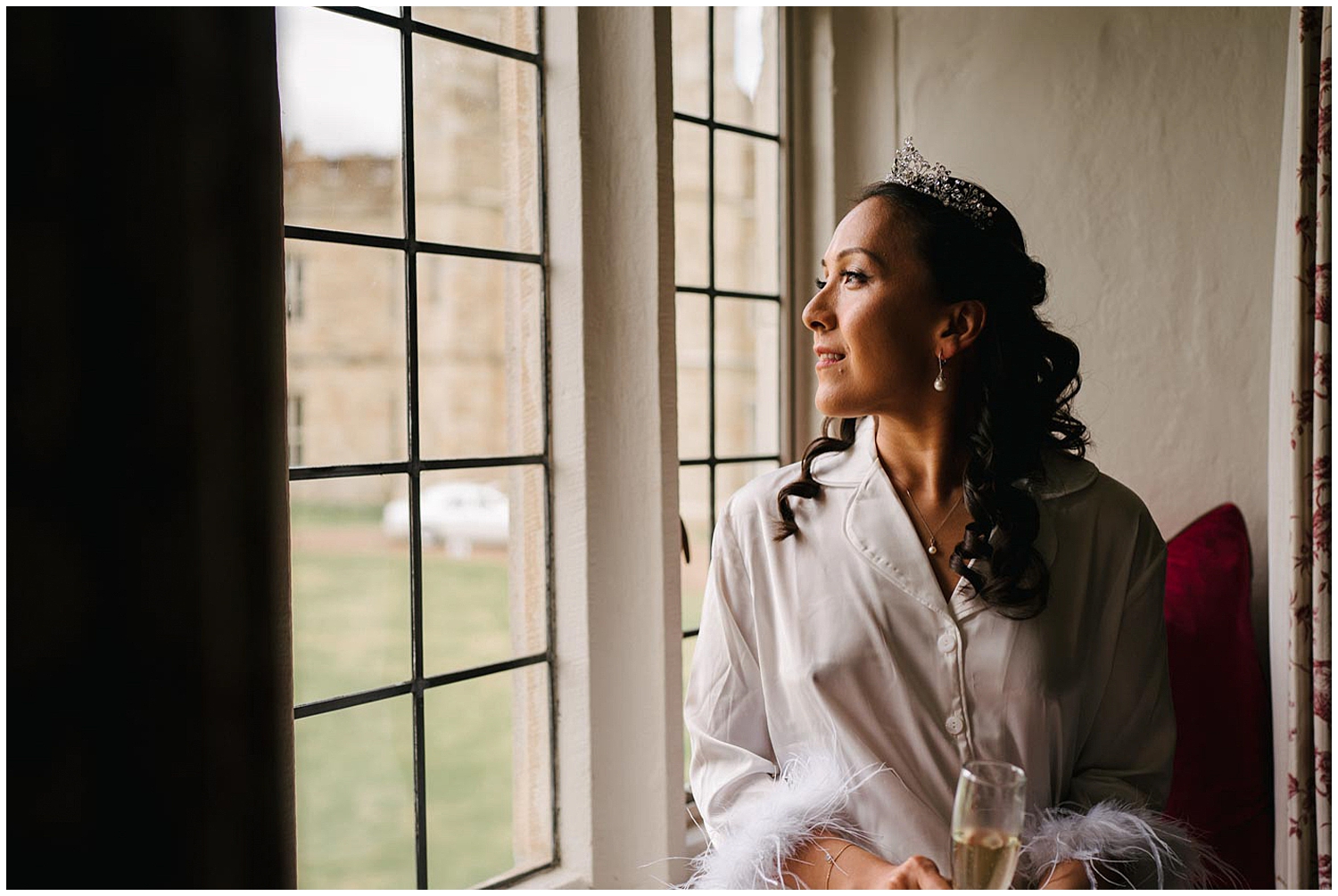 A bride looking out the window before her wedding at Leeds Castle in Kent. Photographed by Kari Bellamy based in Yorkshire. 
