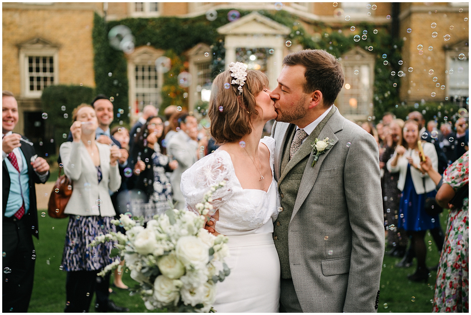 A kiss during the bubbles exit at Hampton Court House School. Photographed by Kari Bellamy. 