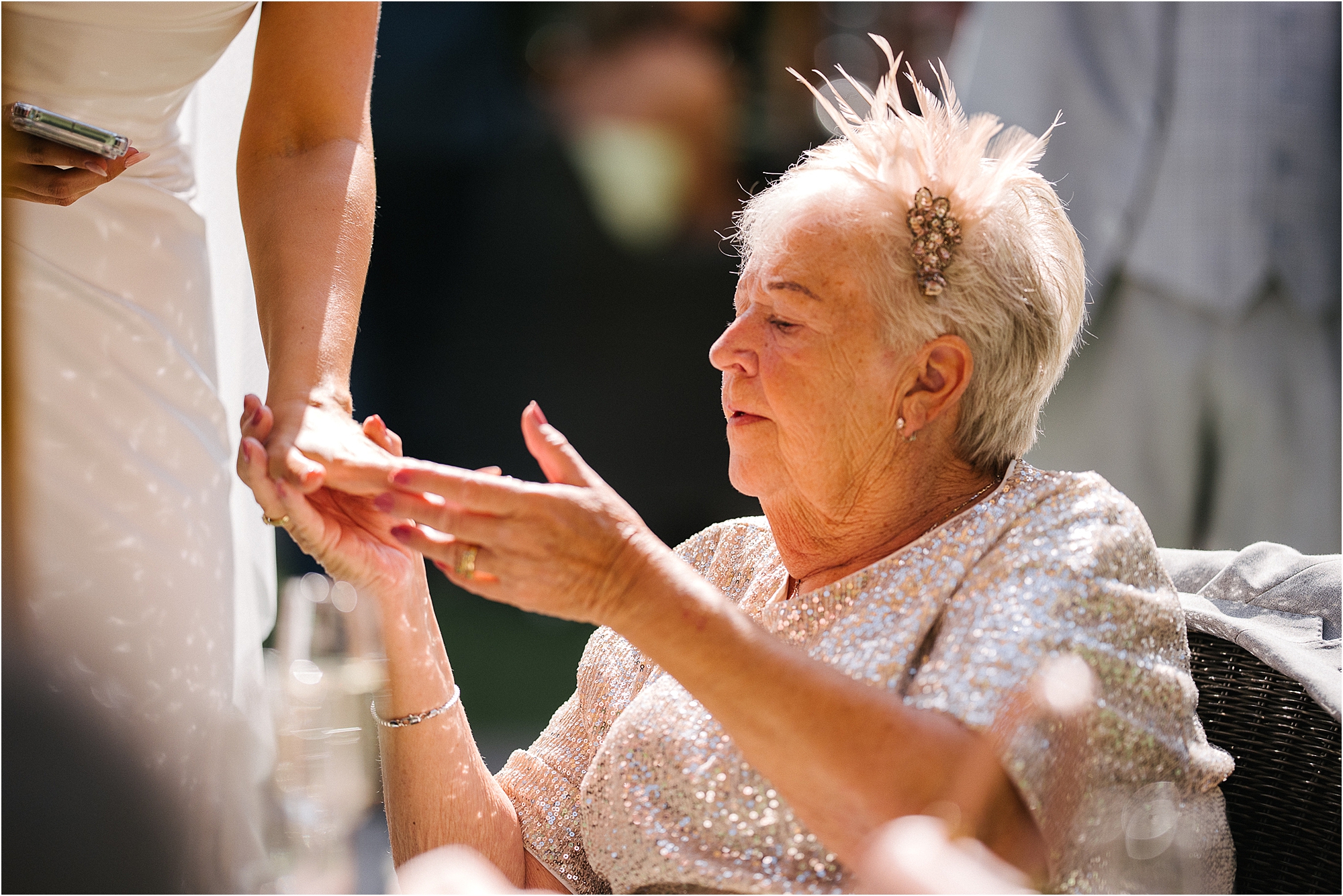 A grandmother admiring the wedding ring of the bride at The Manor House Lindley. 