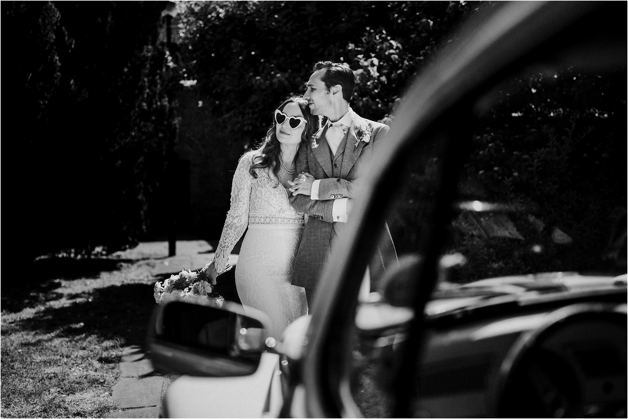 A black and white photo of a wedding couple on a sunny day with VW bug at The Tudor Barn, Eltham, South London. 